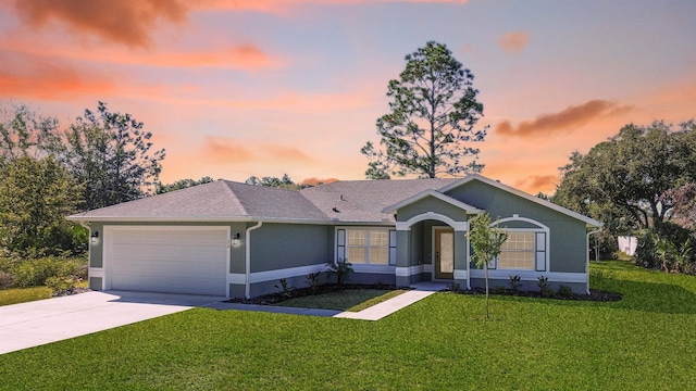 single story home with a garage and a yard