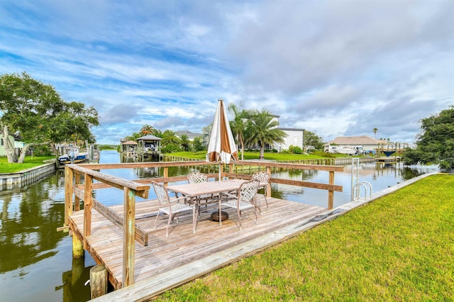 dock area with a yard and a water view