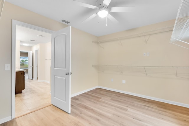 spacious closet with ceiling fan and light wood-type flooring