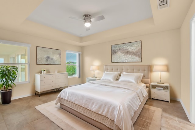 bedroom with ceiling fan and a tray ceiling