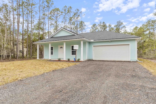 view of front of property featuring a garage, a front lawn, and covered porch