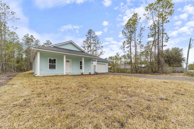 view of front of home featuring a garage, a front yard, and covered porch