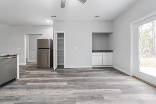 unfurnished living room featuring ceiling fan and light hardwood / wood-style flooring