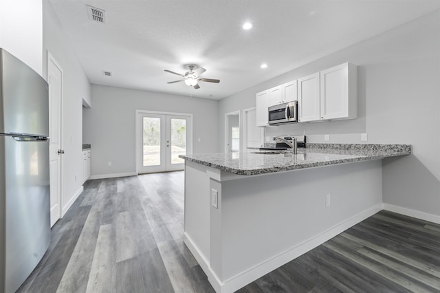 kitchen featuring appliances with stainless steel finishes, white cabinetry, light stone counters, kitchen peninsula, and french doors