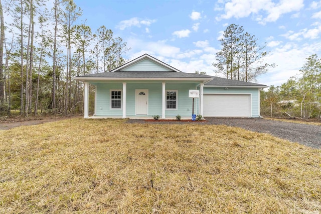 view of front facade featuring a garage, a front yard, and covered porch