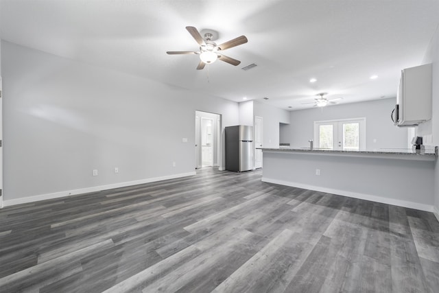 unfurnished living room featuring dark hardwood / wood-style floors, ceiling fan, and french doors