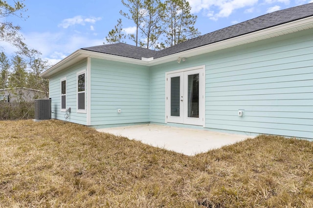 back of house with french doors, a patio area, central air condition unit, and a lawn