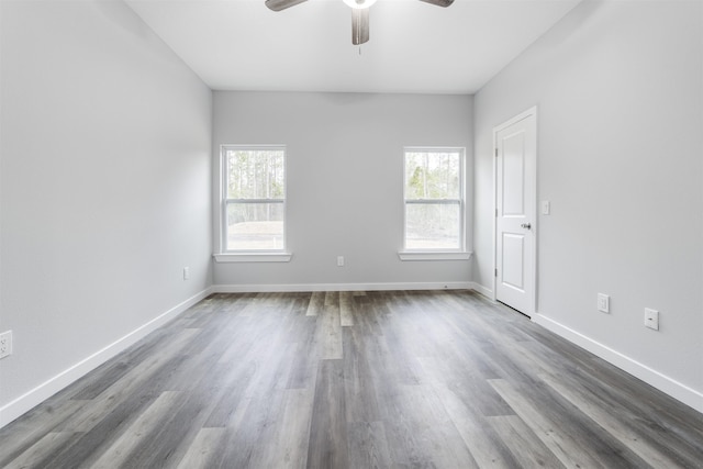 spare room with dark wood-type flooring and ceiling fan