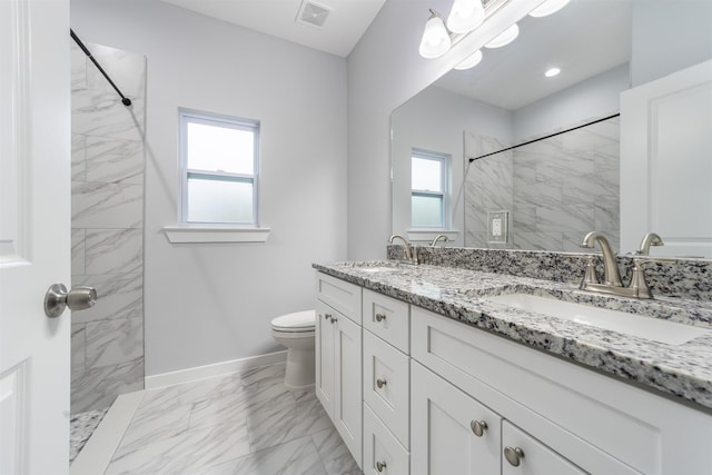 bathroom featuring tiled shower, vanity, and toilet