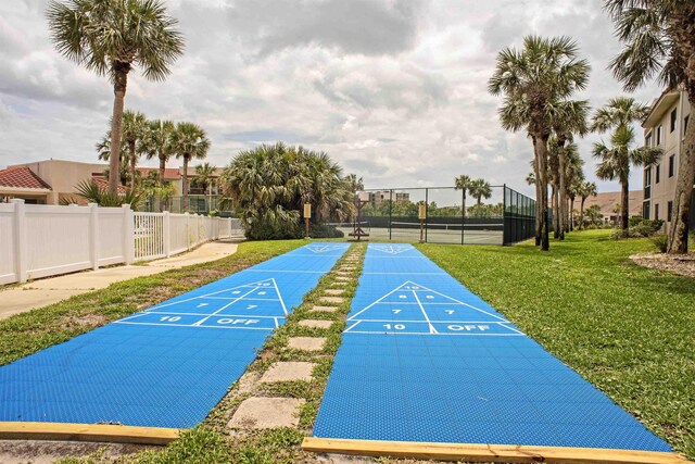 surrounding community featuring tennis court and a lawn