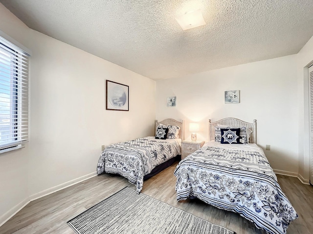 bedroom with a textured ceiling and light hardwood / wood-style flooring