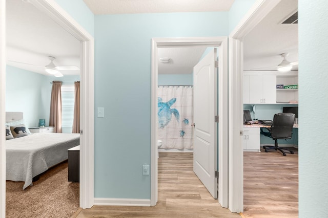 corridor featuring light hardwood / wood-style floors and a textured ceiling