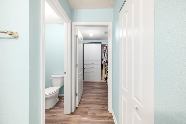 bathroom featuring hardwood / wood-style floors, toilet, and a textured ceiling