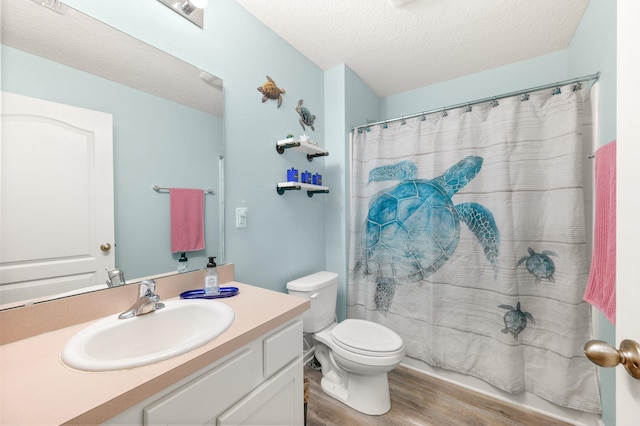 bathroom featuring a shower with curtain, vanity, a textured ceiling, hardwood / wood-style floors, and toilet