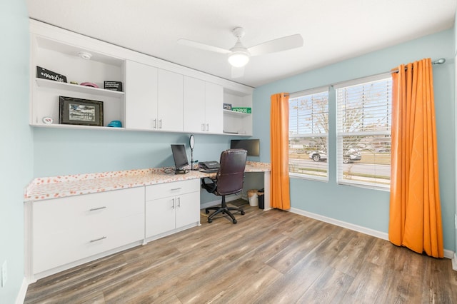 office featuring ceiling fan, built in desk, and hardwood / wood-style flooring