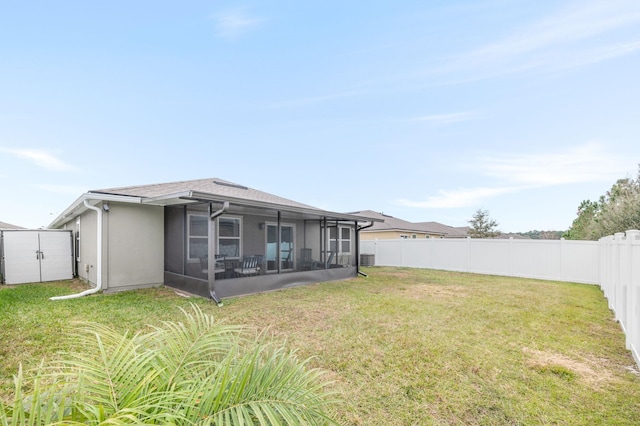 rear view of house with a sunroom and a lawn