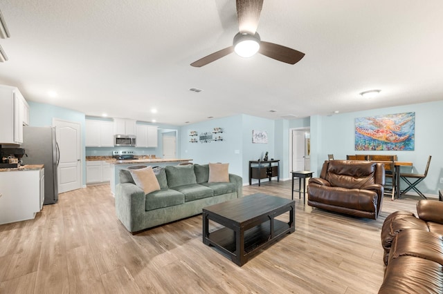 living room with light hardwood / wood-style flooring and ceiling fan