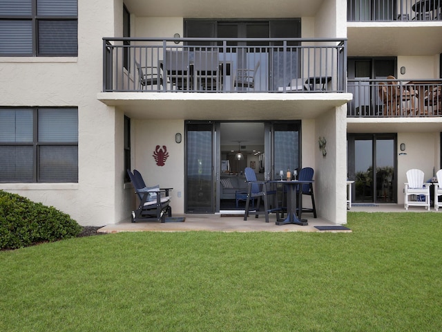 6240 A1A S Unit 103, Saint Augustine, FL 32080 - back of house featuring a patio area, stucco siding, and a lawn