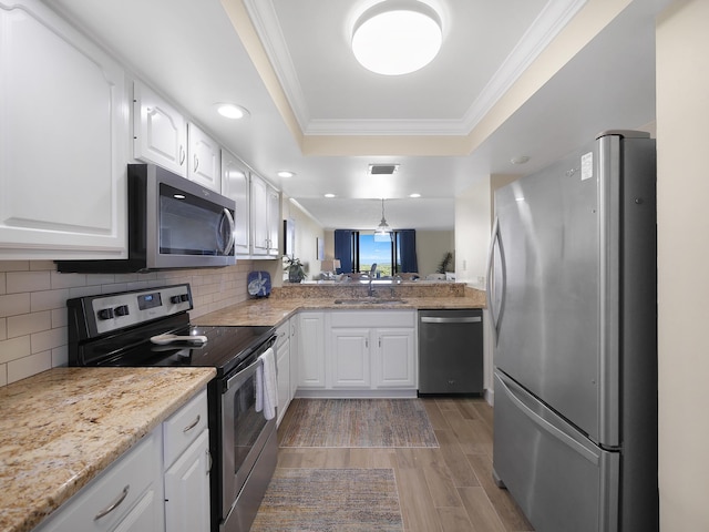 6240 A1A S Unit 103, Saint Augustine, FL 32080 - kitchen with appliances with stainless steel finishes, light wood-type flooring, white cabinets, a raised ceiling, and a sink