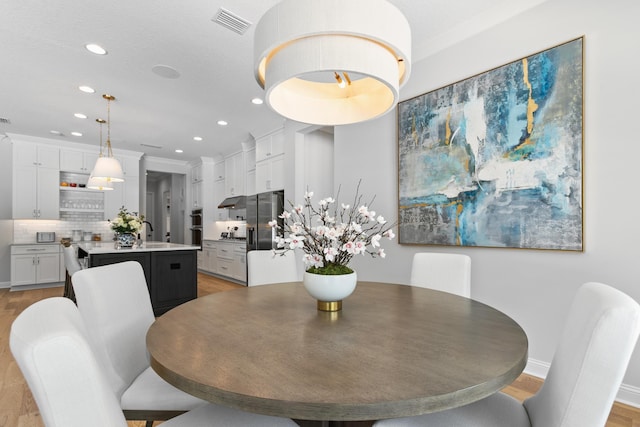 dining area featuring sink and light wood-type flooring