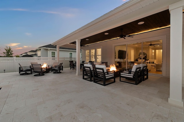 patio terrace at dusk with an outdoor living space with a fire pit and ceiling fan