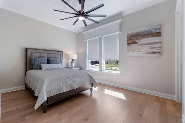 bedroom with crown molding, light hardwood / wood-style floors, and ceiling fan