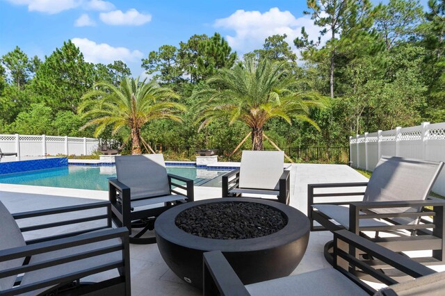 view of patio with a fenced in pool and a fire pit