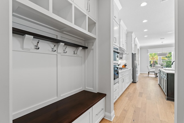 mudroom with sink and light wood-type flooring