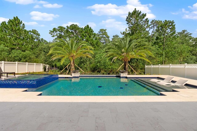 view of pool featuring a patio and an in ground hot tub