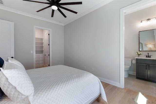 bedroom featuring ensuite bathroom, a spacious closet, a closet, ceiling fan, and light hardwood / wood-style floors