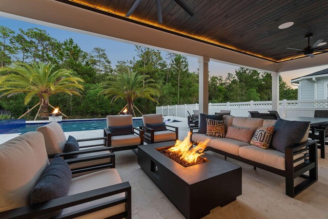 view of patio with ceiling fan and an outdoor living space with a fire pit