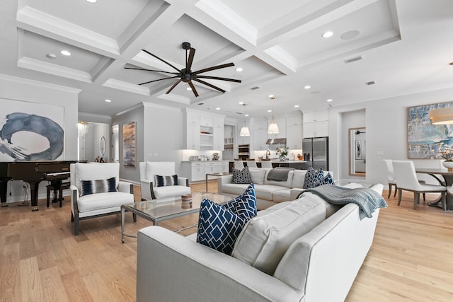 living room with beamed ceiling, coffered ceiling, light hardwood / wood-style floors, and crown molding