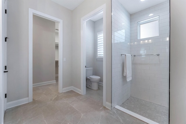 bathroom with toilet and a tile shower