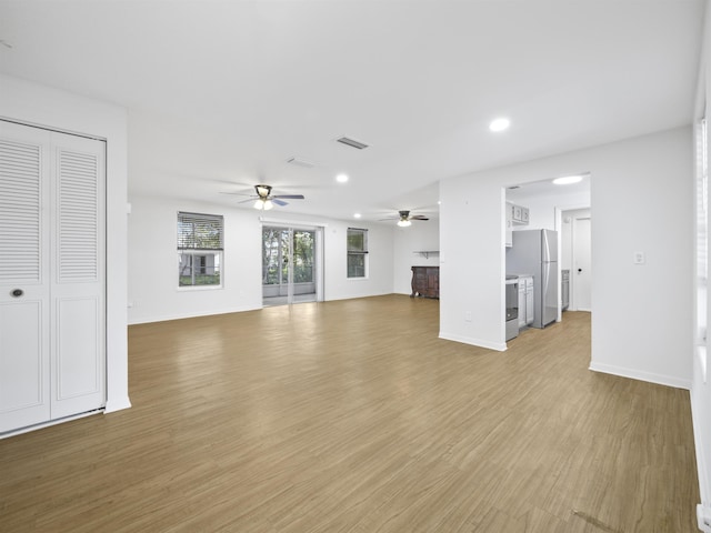 unfurnished living room with ceiling fan and light hardwood / wood-style floors