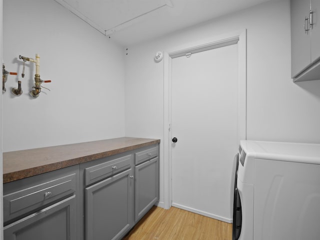 laundry room featuring cabinets and light wood-type flooring