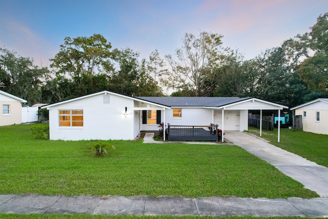 view of front of home featuring a carport and a lawn