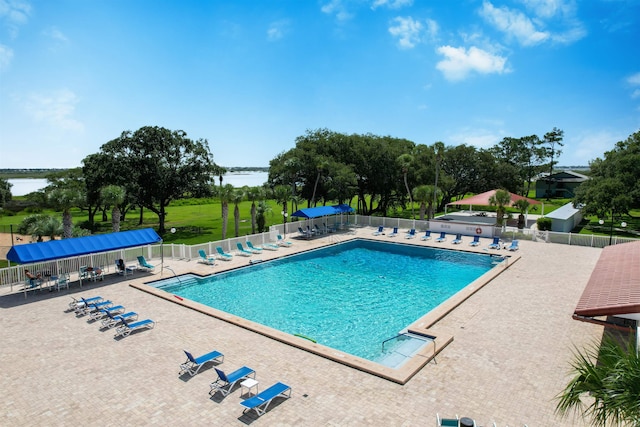 view of swimming pool featuring a water view and a patio