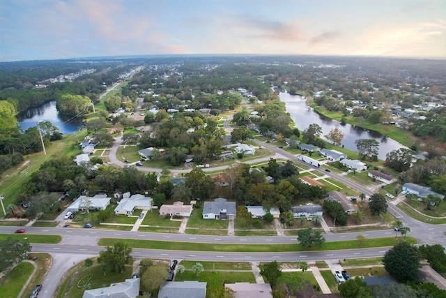 aerial view at dusk featuring a water view