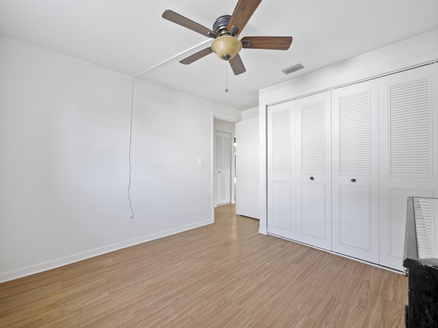 unfurnished bedroom featuring a closet, light hardwood / wood-style flooring, and ceiling fan