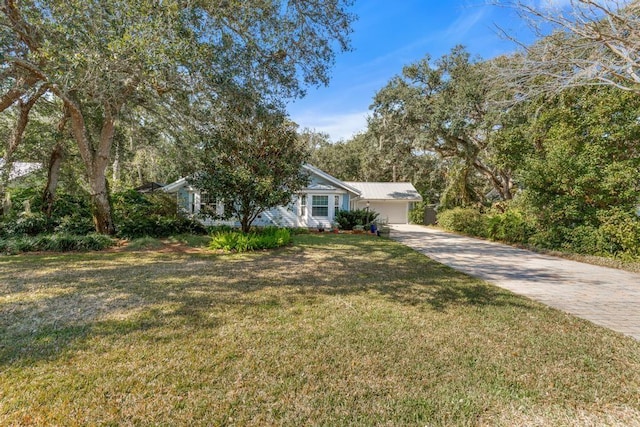 view of front facade featuring a front yard and decorative driveway