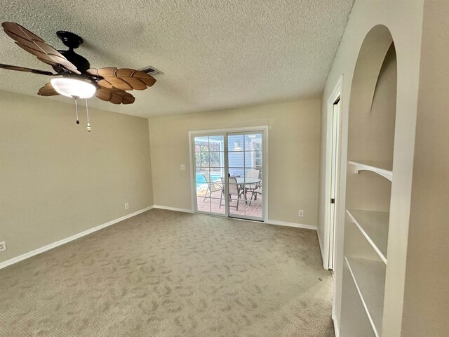 unfurnished room featuring dark colored carpet, plenty of natural light, and a textured ceiling