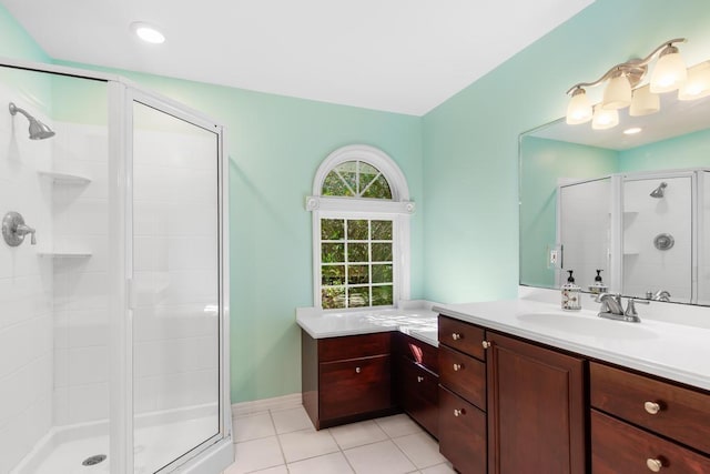 bathroom with tile patterned floors, a shower stall, vanity, and baseboards