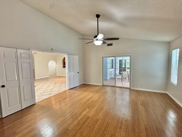 bathroom with a walk in closet, toilet, tile patterned flooring, baseboards, and vanity