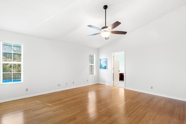 unfurnished room with light wood-type flooring, baseboards, ceiling fan, and vaulted ceiling