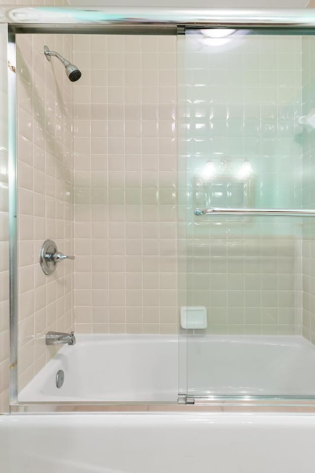 bathroom with bath / shower combo with glass door