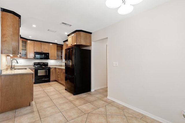 kitchen featuring black appliances, light tile patterned floors, visible vents, and a sink