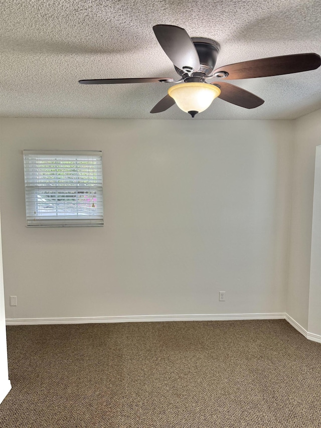 carpeted spare room featuring baseboards, a textured ceiling, and ceiling fan