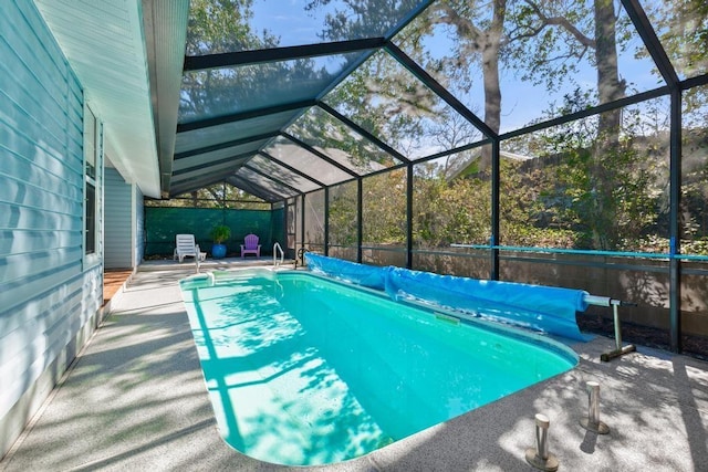 view of pool featuring glass enclosure, a patio, and a covered pool