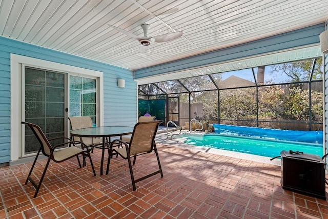 view of patio / terrace featuring a covered pool, a lanai, outdoor dining area, and a ceiling fan