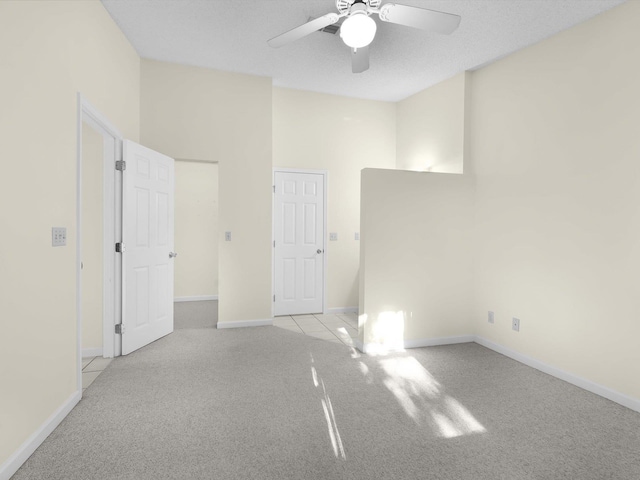 spare room featuring a textured ceiling, light colored carpet, and ceiling fan